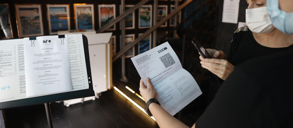 Una metre de un restaurante bilbaíno realiza una comprobación de un pasaporte Covid