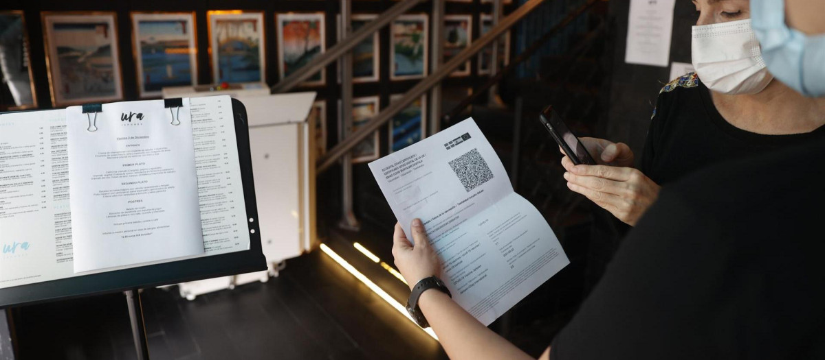 Una metre de un restaurante bilbaíno realiza una comprobación de un pasaporte Covid