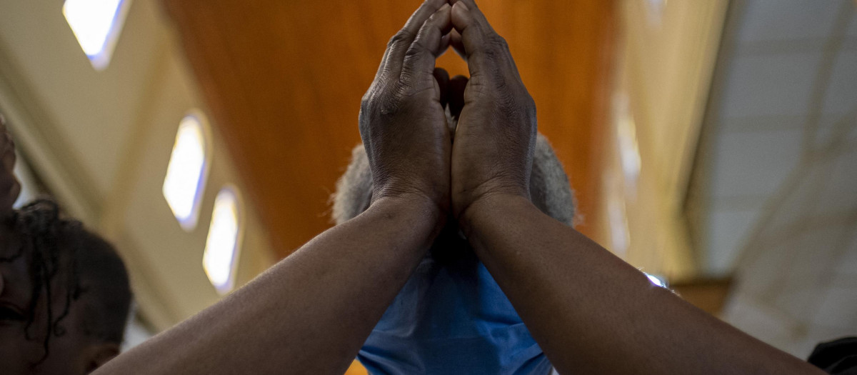 Una mujer reza en una iglesia de Puerto Príncipe, Haití