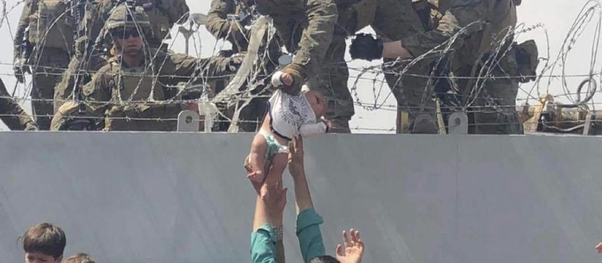 Las familias afganas entregan desesperadas a sus bebés durante la evacuación del aeropuerto, foto de archivo