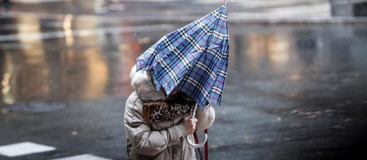 Mujer caminando bajo la lluvia en el norte de España