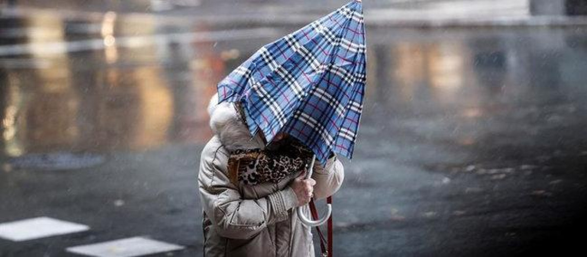 Mujer caminando bajo la lluvia en el norte de España