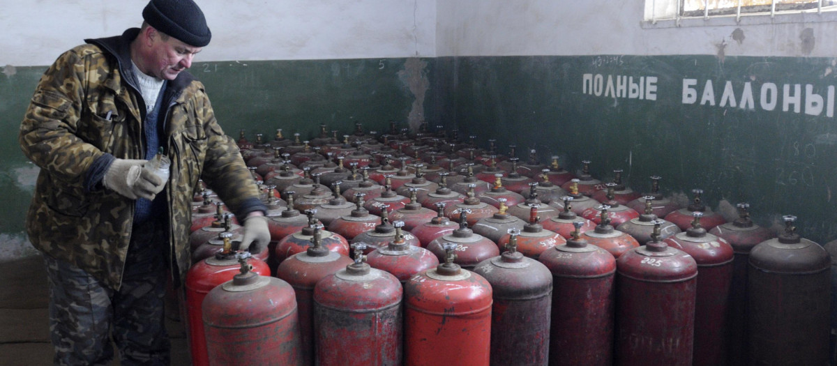 Un trabajador ucraniano se prepara para cargar contenedores de gas en la ciudad de Brovary al noroeste de Kiev