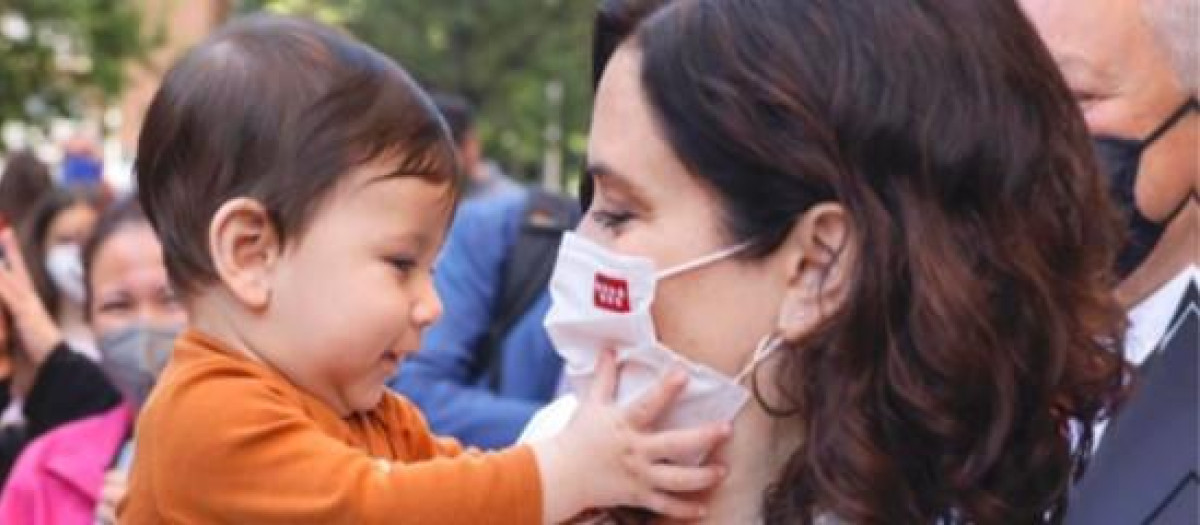 La presidenta Isabel Díaz Ayuso con un niño
