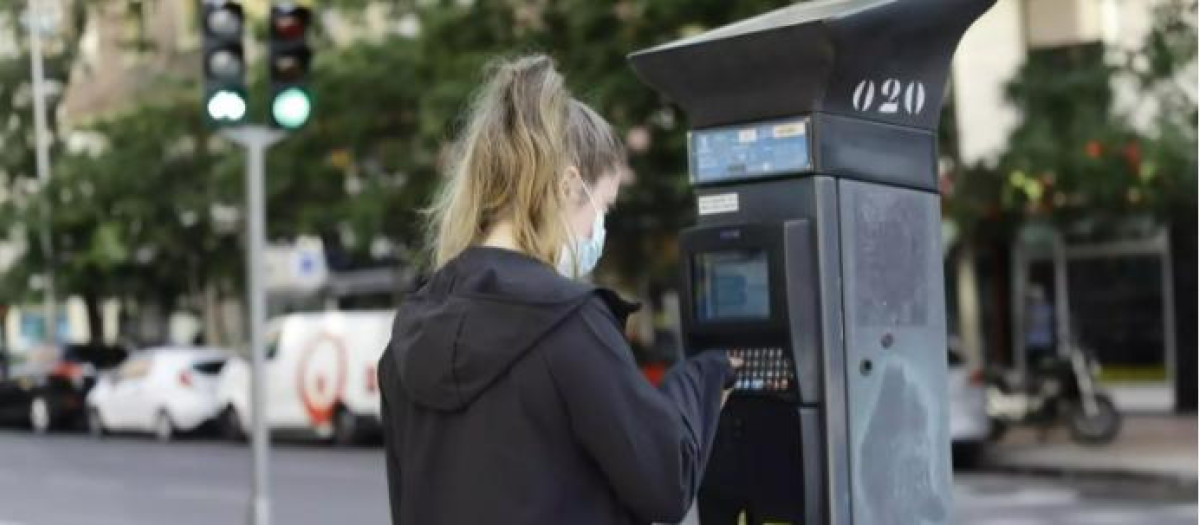 Una joven utiliza un parquímetro del Servicio de Estacionamiento Regulado