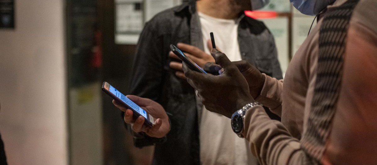 Una mujer muestra el pasaporte Covid al entrar a un local de ocio nocturno