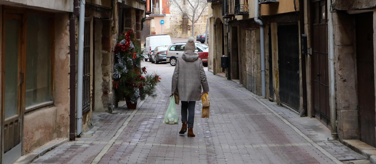 Una mujer camina por la calle con abrigo y gorro