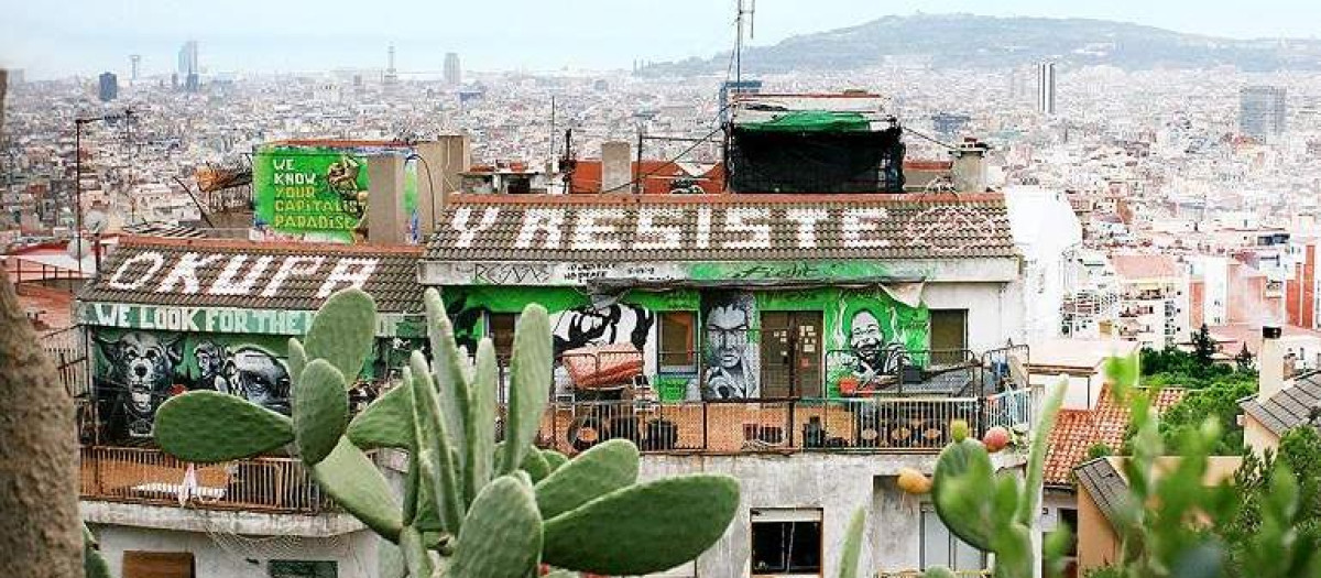 Vista aérea de una vivienda con una pintada que incita a la okupación en Barcelona