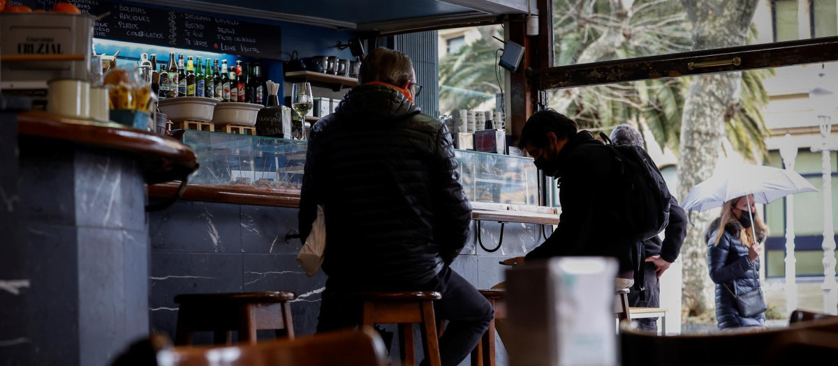 Dos hombres consumen en la barra de un bar de San Sebastián, donde desde este lunes el Gobierno Vasco ha relajado las restricciones impuestas por la pandemia