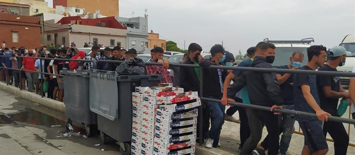 Varios inmigrantes marroquíes hacen cola para recibir el menú de una ONG, el pasado julio