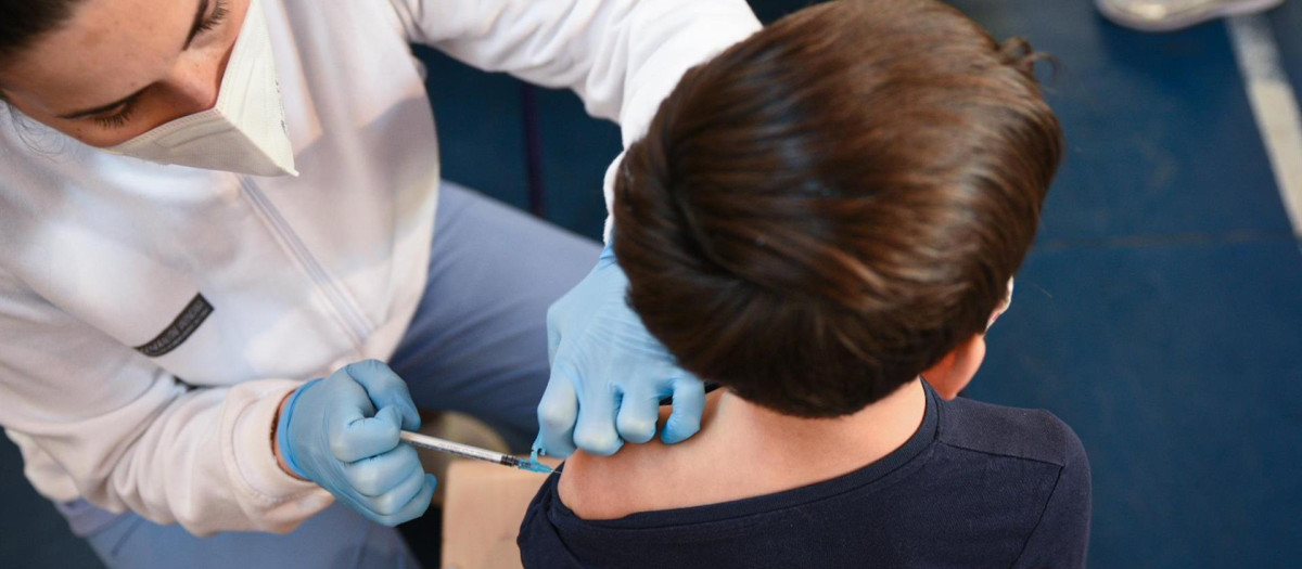 Un niño recibe la vacuna contra la covid en un colegio de Valencia