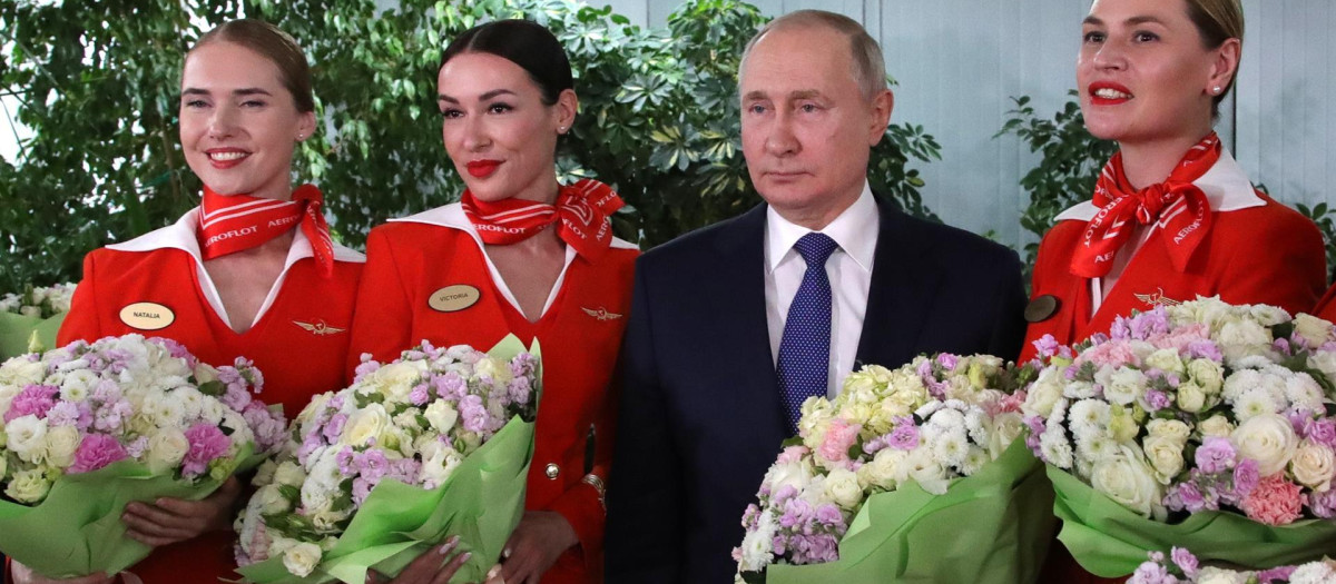 El presidente ruso, Vladimir Putin (2-R), posa para fotografías con mujeres de la tripulación de vuelo de las aerolíneas rusas durante su visita al centro de entrenamiento de aviación de PJSC Aeroflot