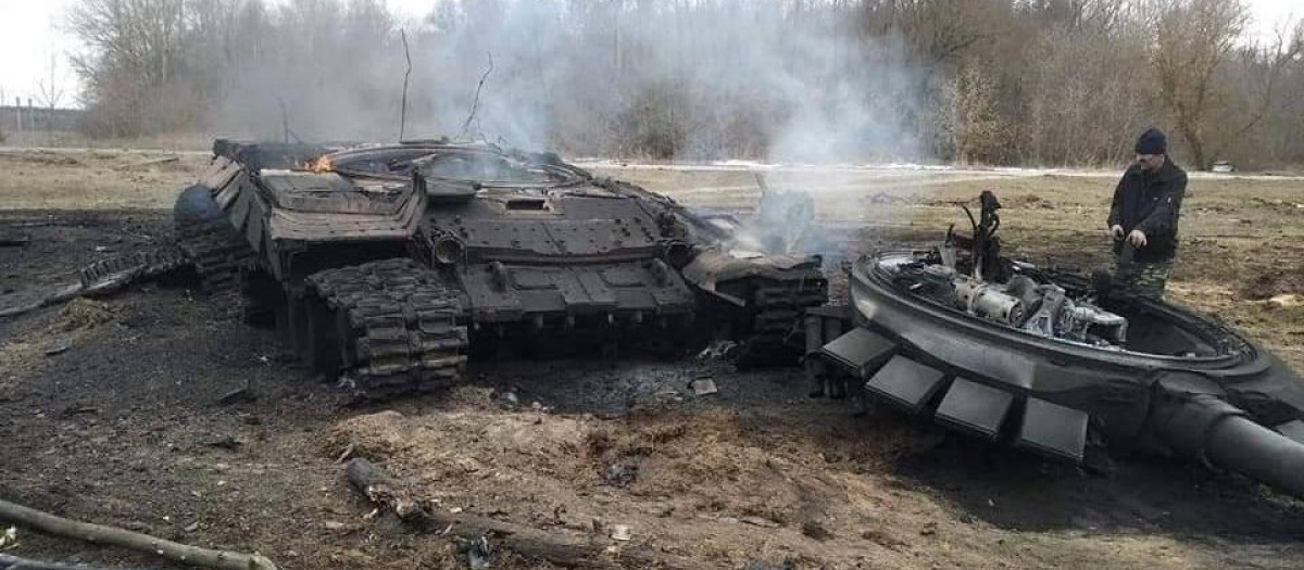 Un soldado ucraniano, junto a un tanque ruso destruido