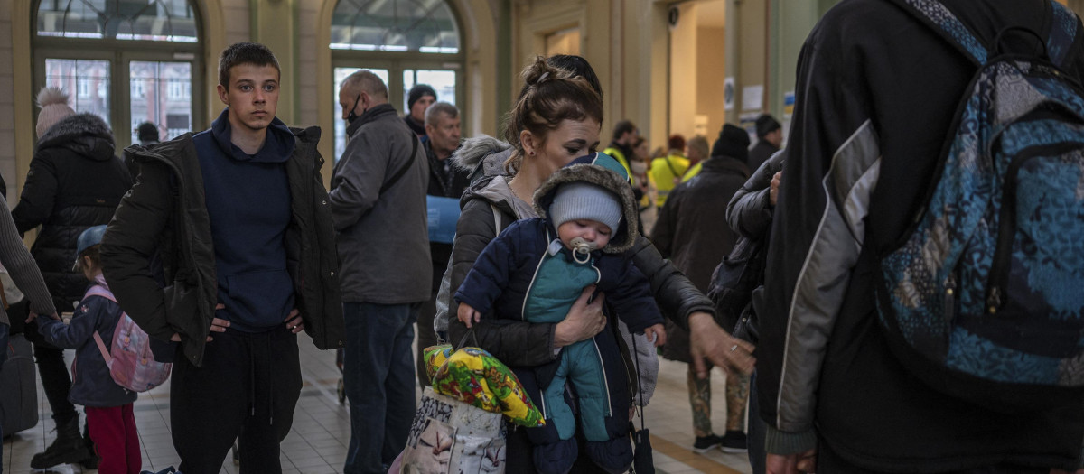 Refugiados de Ucrania hacen fila para obtener boletos de tren gratuitos en el vestíbulo de la estación principal de trenes en Przemysl, sureste de Polonia