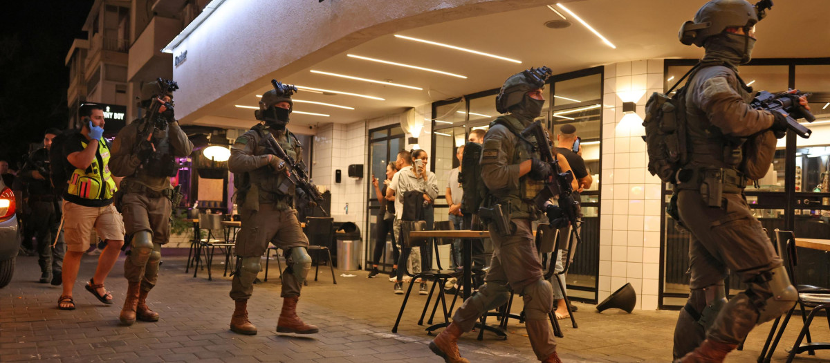 Las fuerzas de seguridad se reúnen frente a un restaurante en el lugar de un tiroteo en la calle Dizengoff