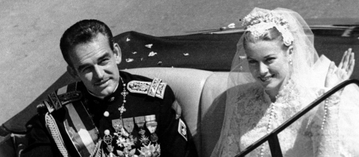 Princess Grace Kelly waves to cheering crowds lining the road as she rides in an open car with Prince Rainier III following their marriage in a religious wedding ceremony in the Monaco Cathedral, South of France, April 19, 1956. (AP Photo)© RADIAL PRESS