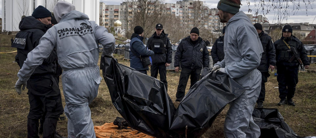 Personal forense trabaja en la zona donde han encontrado una fosa común detrás de la iglesia St Andrew Pervozvannoho, hoy, en Bucha (Ucrania)