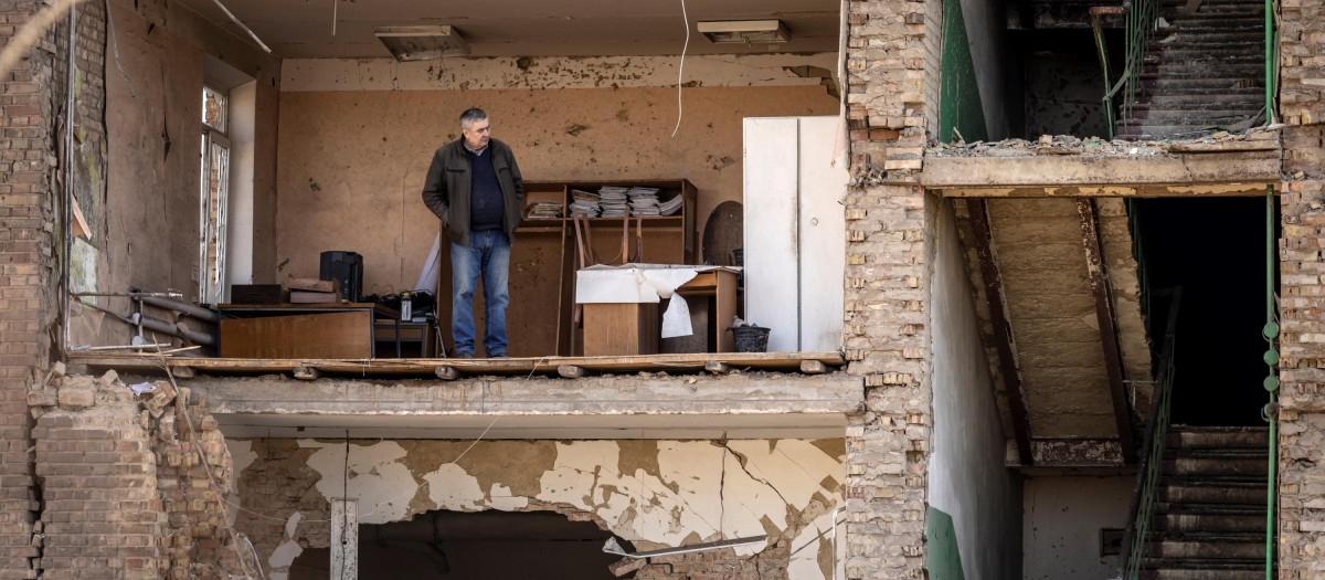 Un hombre se para en un edificio con una fachada derrumbada en el complejo militar-industrial de la compañía Vizar, luego de que el sitio fuera atacado durante la noche por ataques rusos, en la ciudad de Vyshneve.