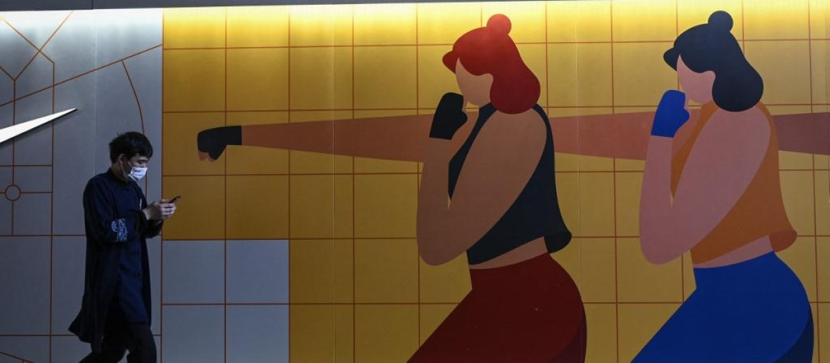 Un hombre pasea junto a un centro comercial en Pekín