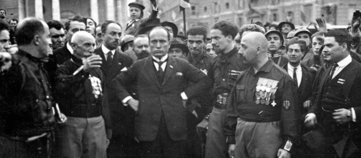 El líder fascista italiano Benito Mussolini, en el centro, con las manos en las caderas, con miembros del Partido fascista, en Roma, Italia, el 28 de octubre de 1922, luego de su Marcha sobre Roma