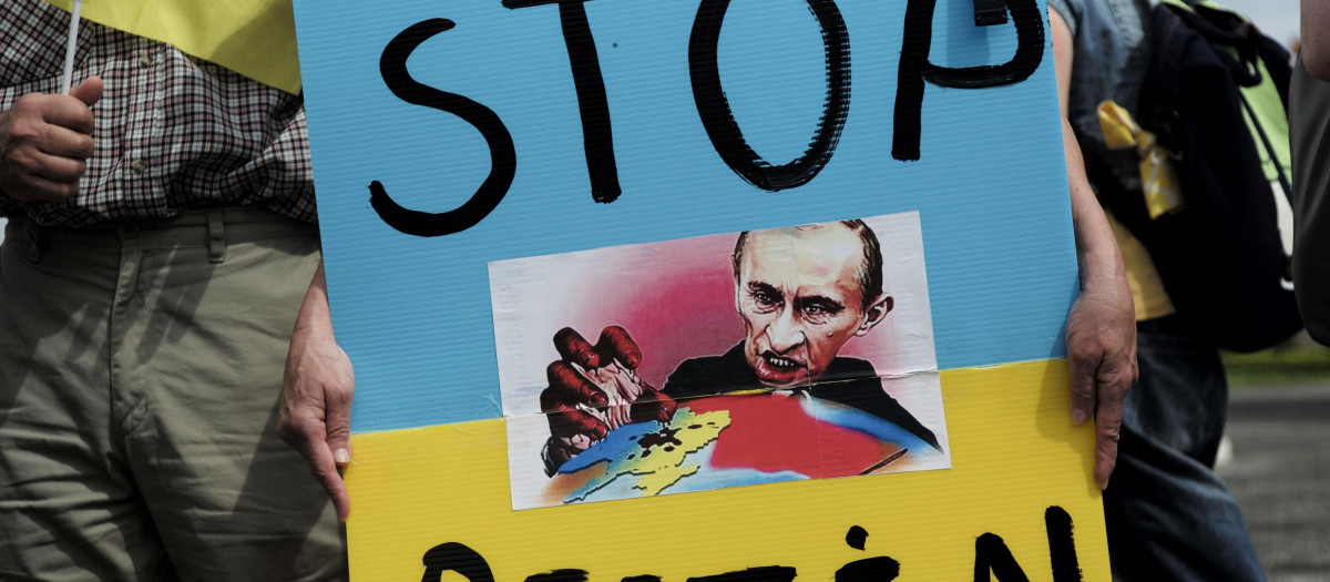 Slavic people living in Taiwan display a poster with an image depicting Russia's President Vladimir Putin during a rally at the Free Square in front of the Chiang Kai-shek Memorial Hall in Taipei on May 8, 2022. (Photo by Sam Yeh / AFP)