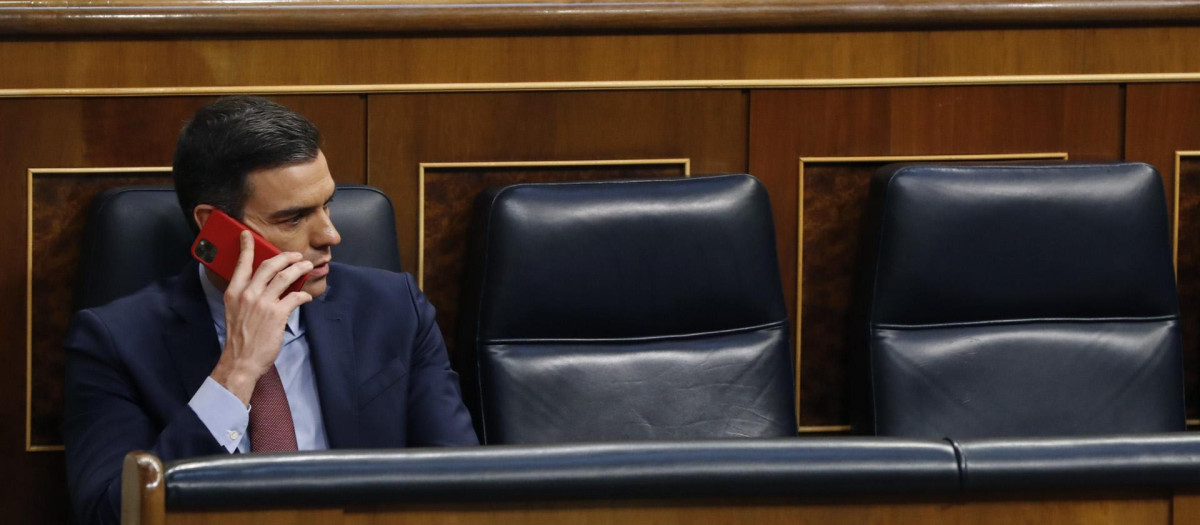 El presidente Pedro Sánchez hablando con su teléfono móvil