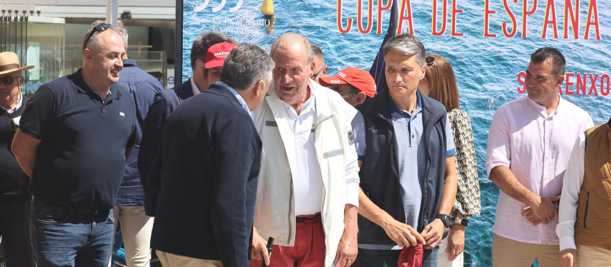El Rey Juan Carlos habla con el alcalde de Sansenxo, Telmo Martín, a su llegada al Náutico de la localidad gallega