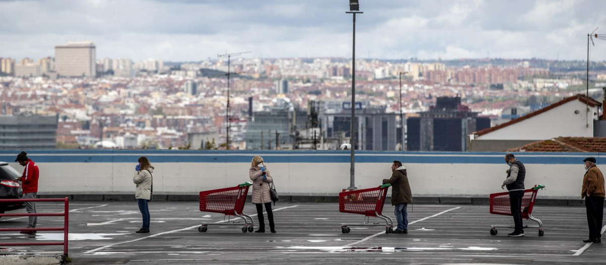Personas esperando para entrar a un supermercado en Vallecas durante el estado de alarma por la crisis del Covid-19 en Madrid