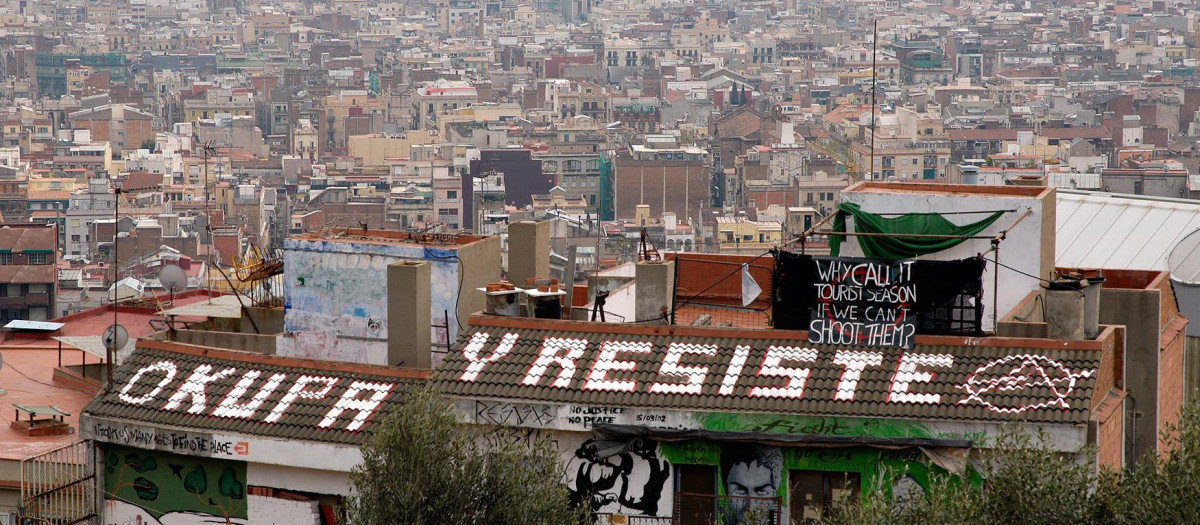 Una pintada okupa en un edificio cercano al Parc Güell de Barcelona