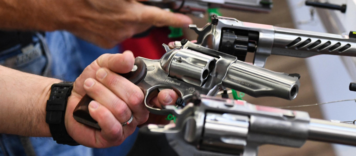 Attendees hold Ruger revolver pistols during the National Rifle Association (NRA) Annual Meeting at the George R. Brown Convention Center, in Houston, Texas on May 28, 2022. - America's powerful National Rifle Association kicked off a major convention in Houston Friday, days after the horrific massacre of children at a Texas elementary school, but a string of high-profile no-shows underscored deep unease at the timing of the gun lobby event. (Photo by Patrick T. FALLON / AFP)