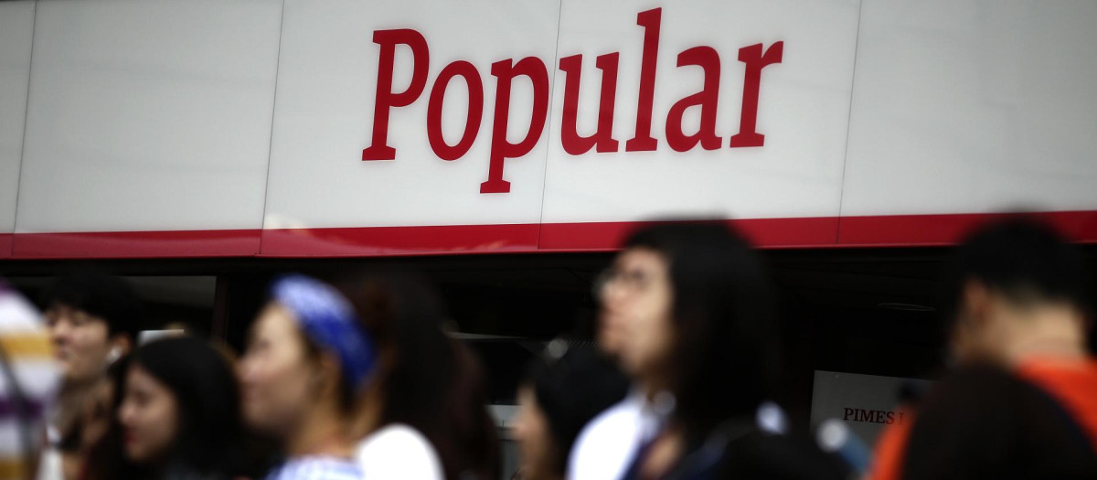 Un grupo de personas se congrega frente a una oficina de Banco Popular en Barcelona