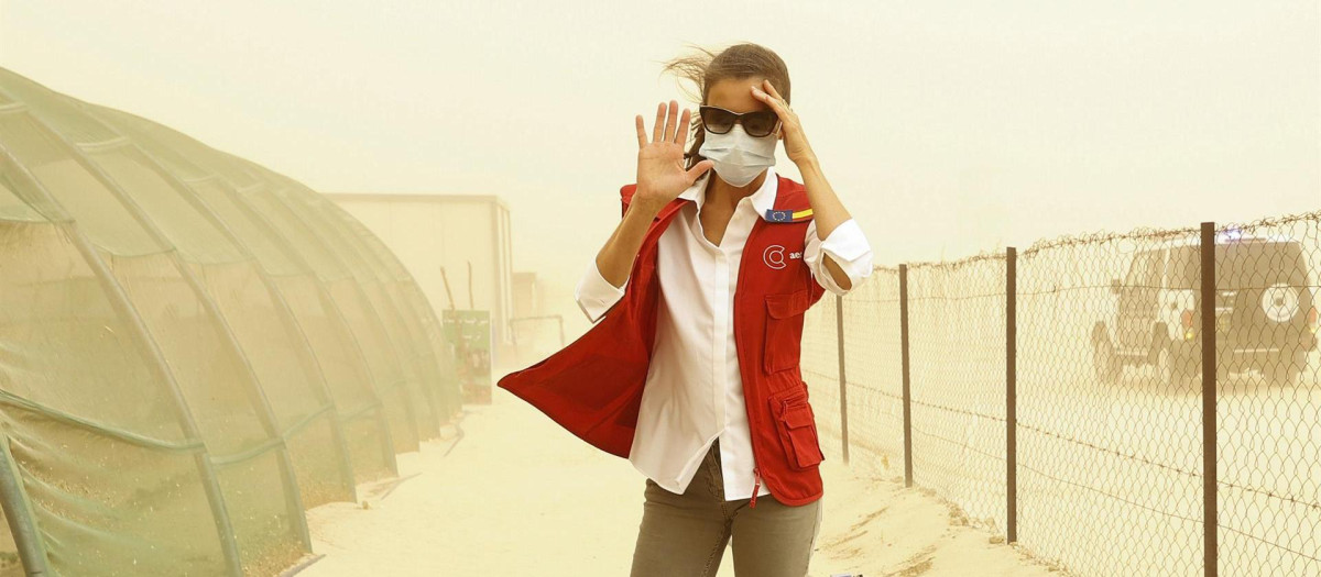 La Reina Letizia, con gafas y mascarilla al verse sorprendida por una tormenta de arena, durante su viaje de cooperación por Mauritania