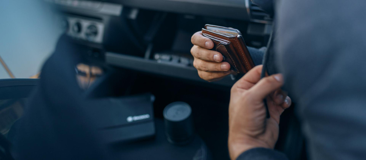 Un ladrón roba una cartera de la guantera de un coche