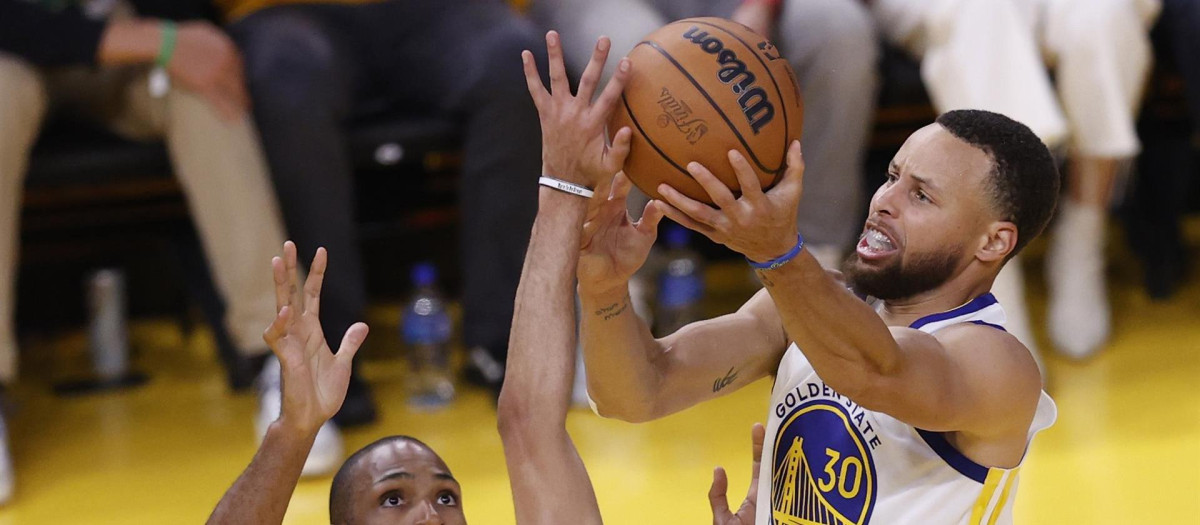 Stephen Curry lanza ante dos rivales