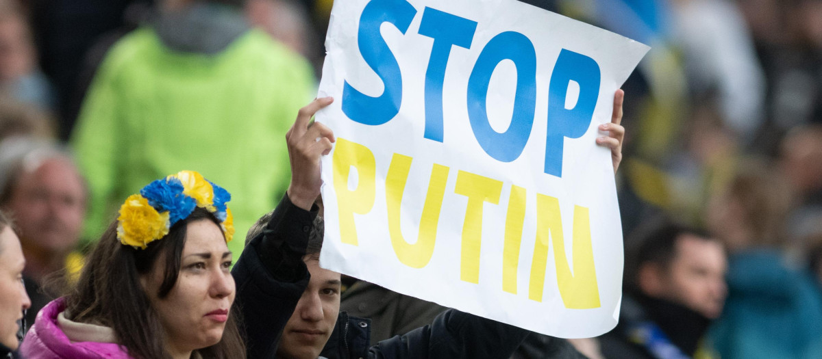 Jóvenes ucranianos protestan contra la invasión de Putin a Ucrania con un mensaje en inglés
