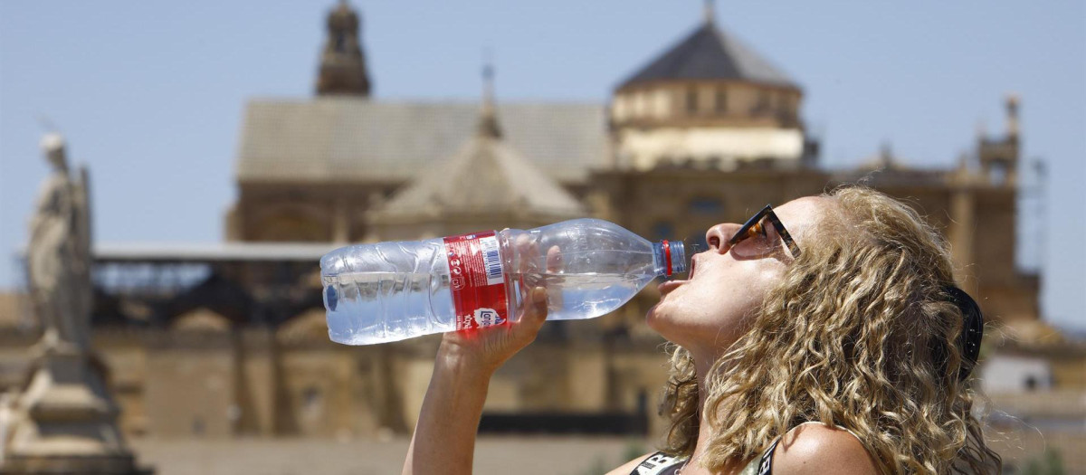 Una turista bebe agua para combatir el calor, en Córdoba, ante las altas temperaturas que registra la Península por la ola de calor
