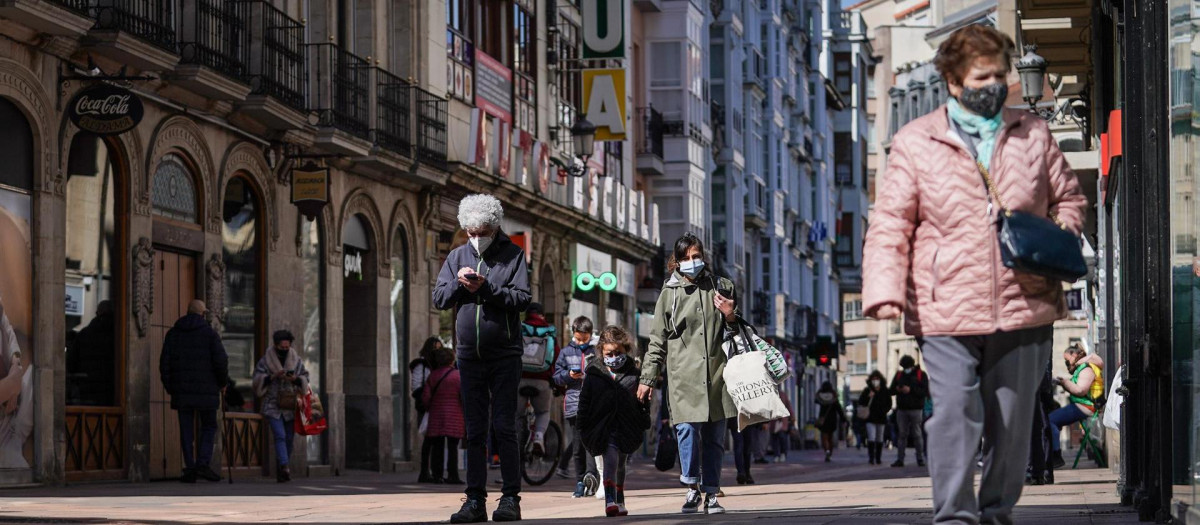 Varias personas mayores caminan por una calle céntrica de Vitoria.