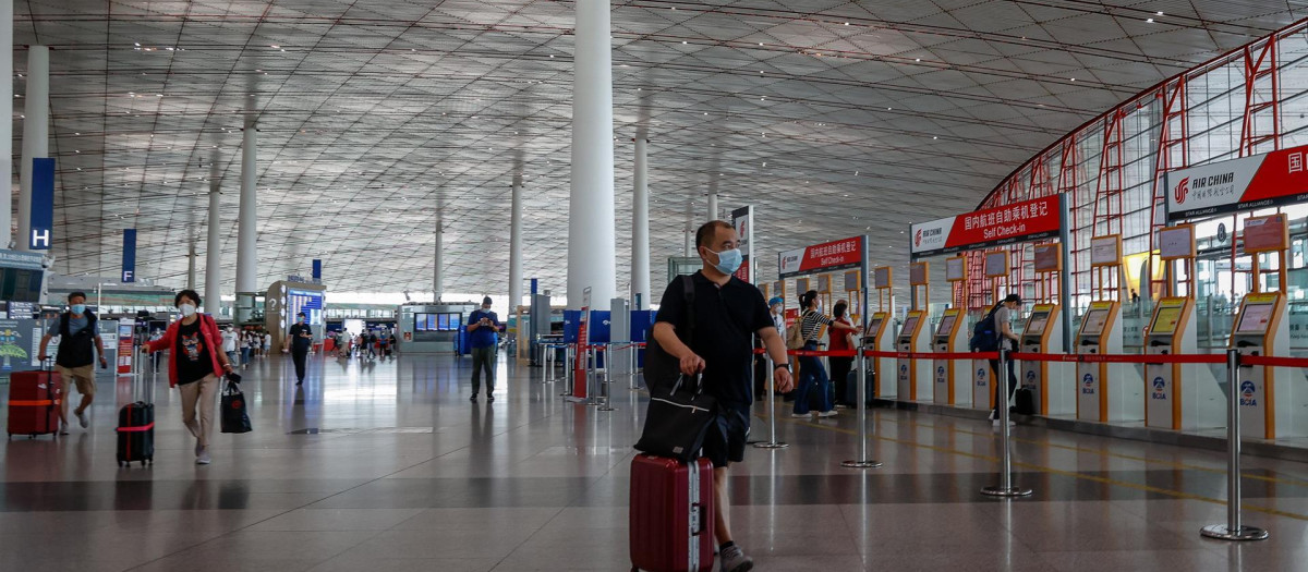Varias personas caminan por el Aeropuerto Internacional de Pekín, en China, este miércoles. China ha reducido el periodo de cuarentena de las llegadas del extranjero con la permanencia de siete días en un centro gestionado por el gobierno y tres días en arresto domiciliario