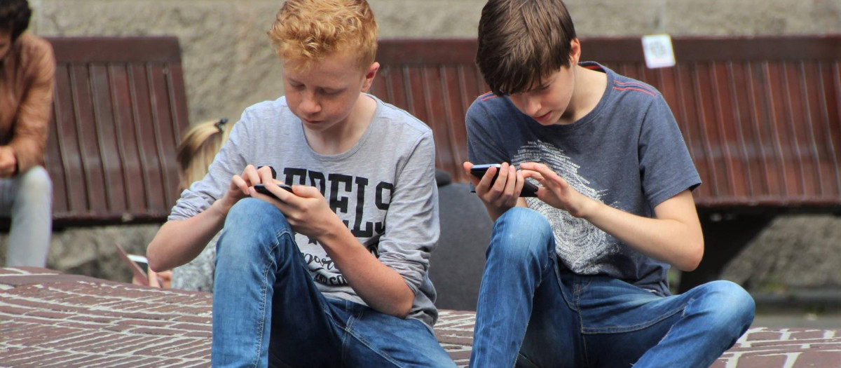 Dos adolescentes con el teléfono móvil