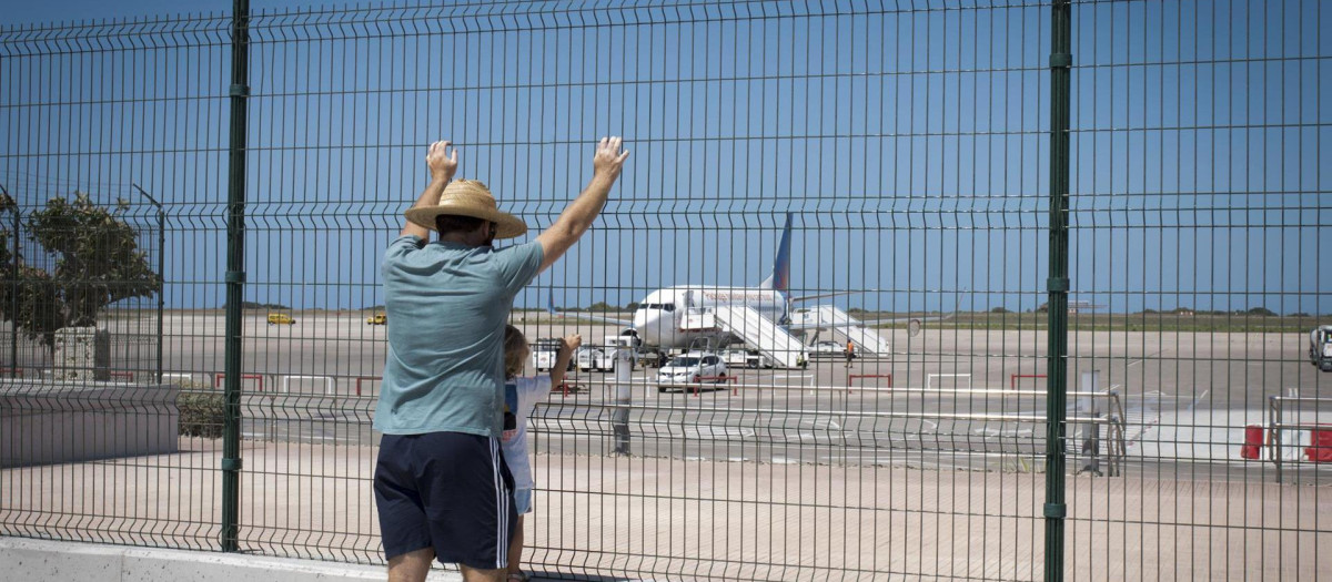 Varias personas observan aviones en aeropuerto de Menorca en el primer día del mes de julio