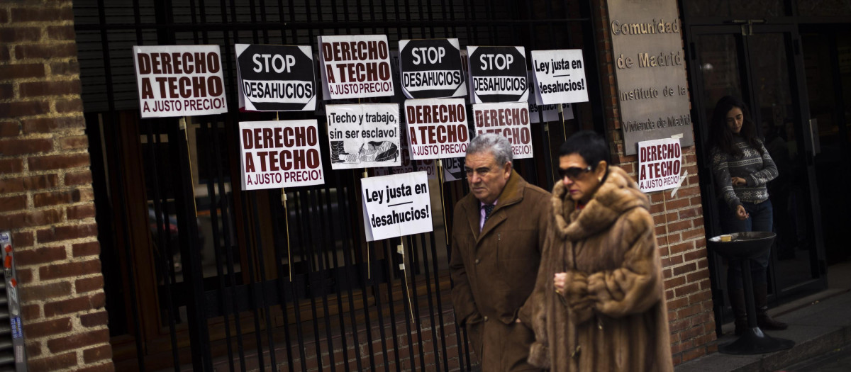 Una pareja camina frente a la oficina del Instituto de la Vivienda de Madrid