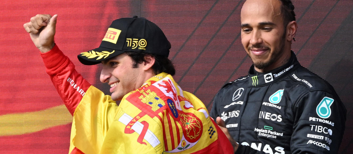 Carlos Sainz, con la bandera de España, al lado de Hamilton, que quedó tercero