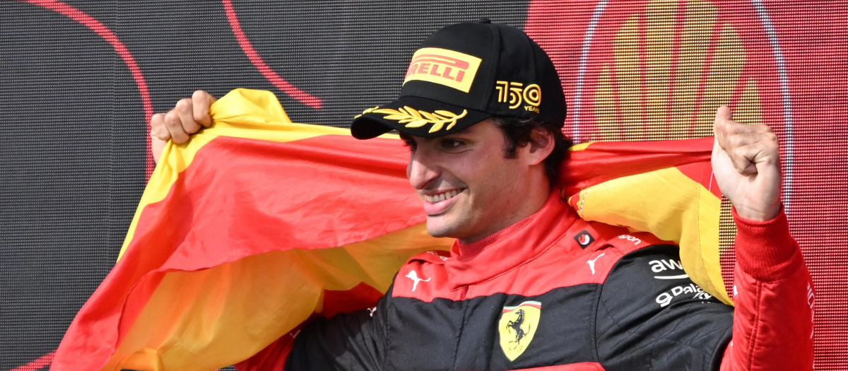 Carlos Sainz, engalanado con la bandera de España, celebra su victoria en Silverstone