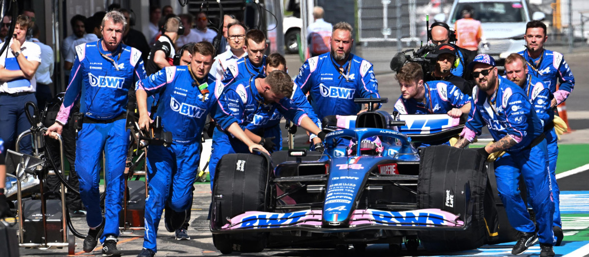 Los mecánicos de Alpine arrastran el monoplaza de Fernando Alonso