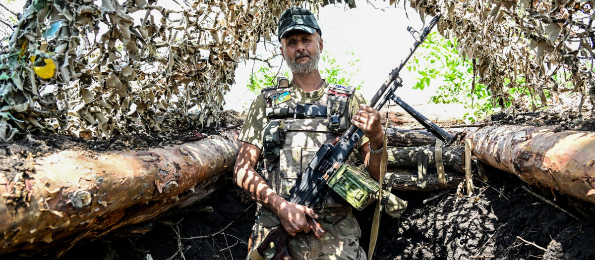 A Ukrainian soldier poses in a trench near the front line in eastern Ukraine, on July 13, 2022, amid the Russian invasion of Ukraine. (Photo by MIGUEL MEDINA / AFP)