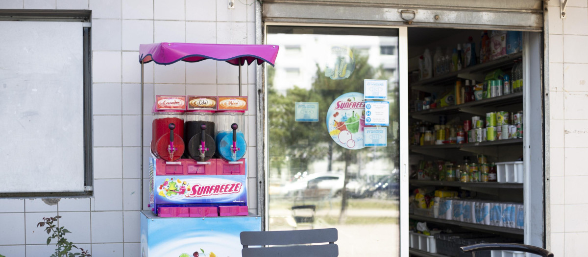 Un comercio francés con una máquina de venta de granizados en su exterior y la puerta abierta
