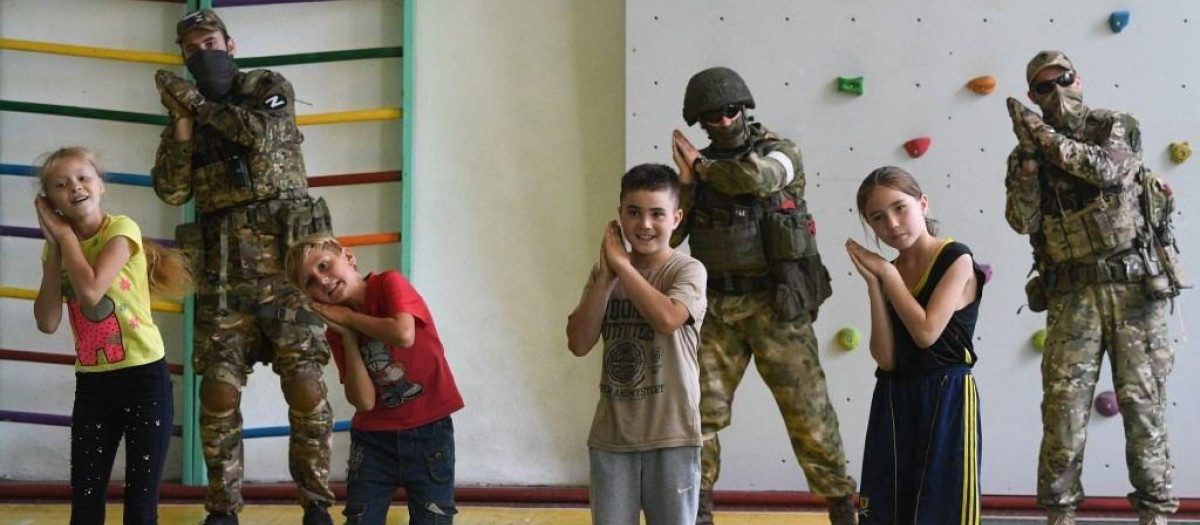 Niños ucranianos junto a soldados rusos