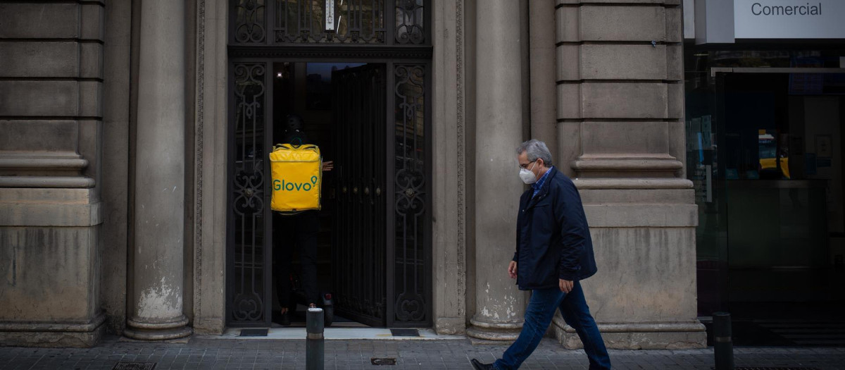 Un trabajador de Glovo entra en un portal
