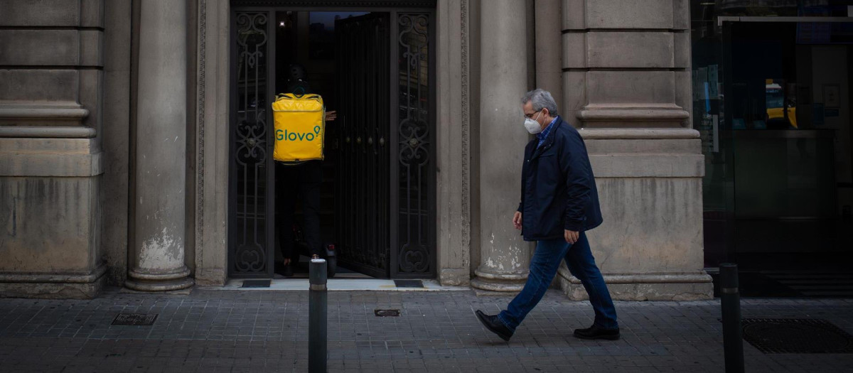 Un trabajador de Glovo entra en un portal