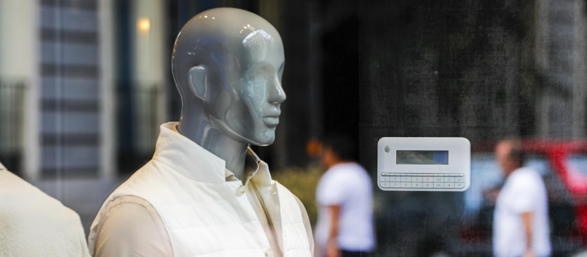 Un escaparate de un comercio con un maniquí y un termostato